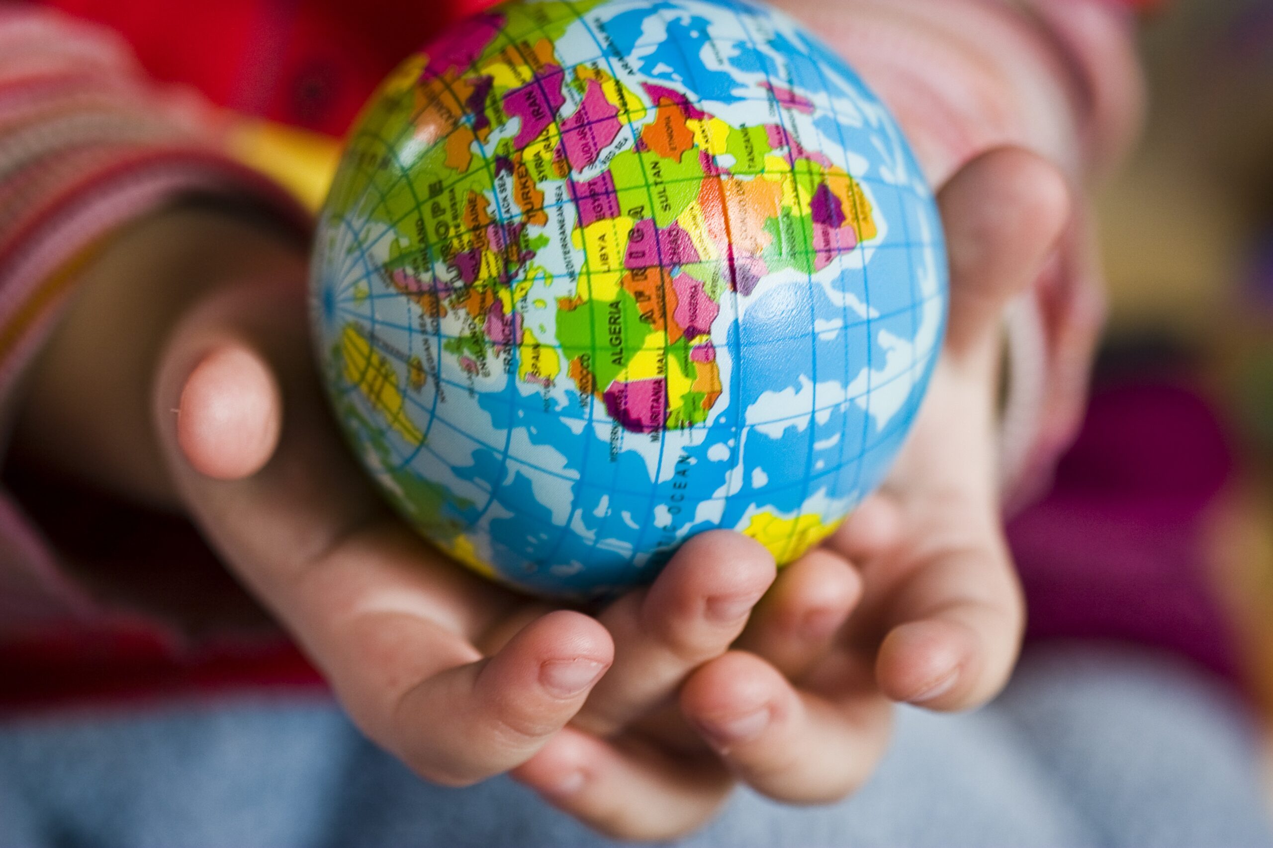 Enfant tenant une mappemonde. « L’enfant et les langues » : article par Jean-Pierre Bauer